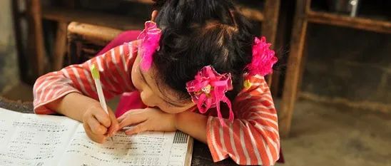 凤凰网“美丽童行”助学活动记录下趴在桌上专心做习题