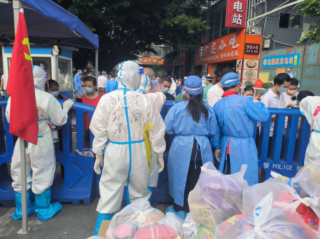 郭璇（左三）在为居民派发爱心物资包