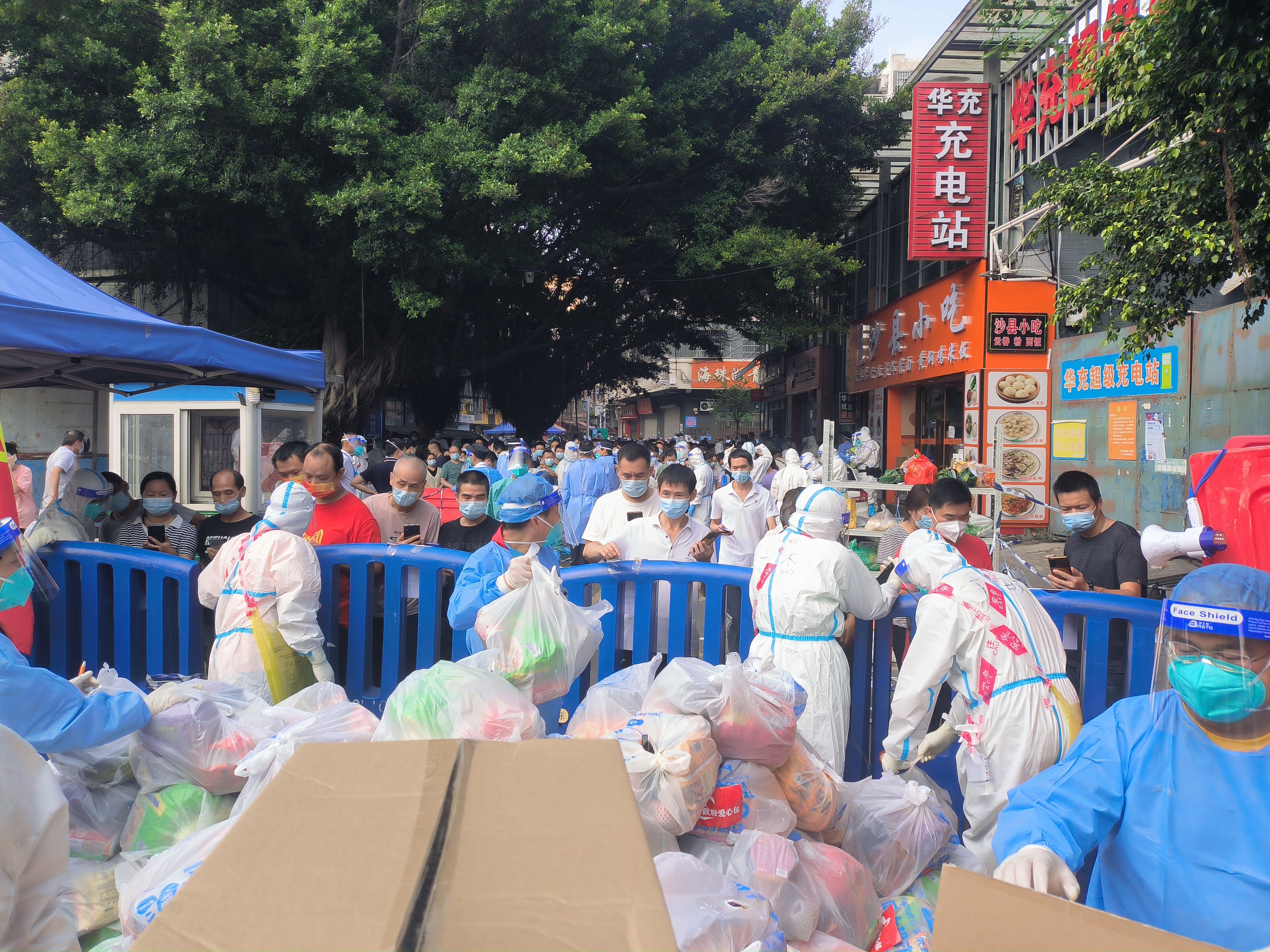 蓝海滨（左二 ）为居民派发爱心物资包